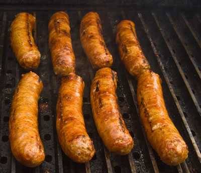Sausages laid between the rungs on the grill