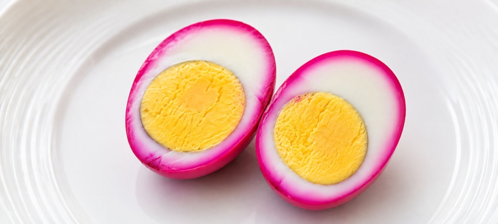 Halved pickled egg with red ring around the exterior.