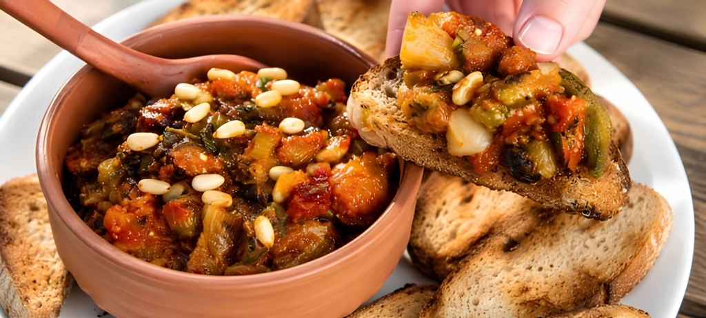 Eggplant caponata in a bowl and on a piece of tasted bread.
