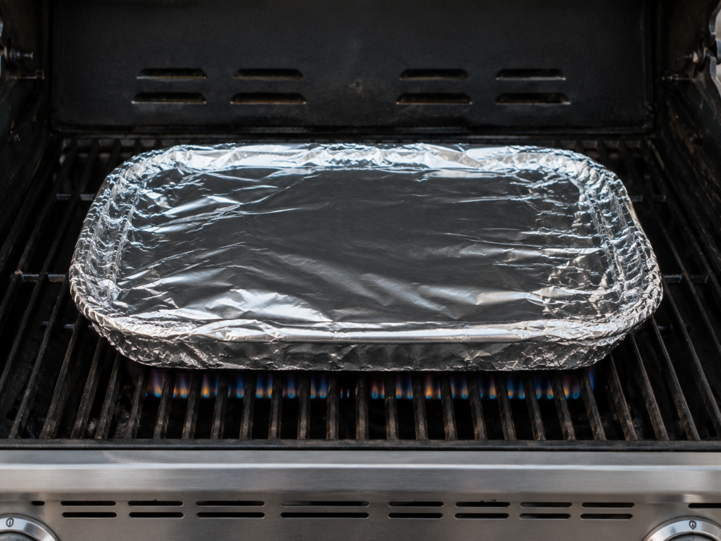 Lasagna wrapped in aluminium foil on a grill