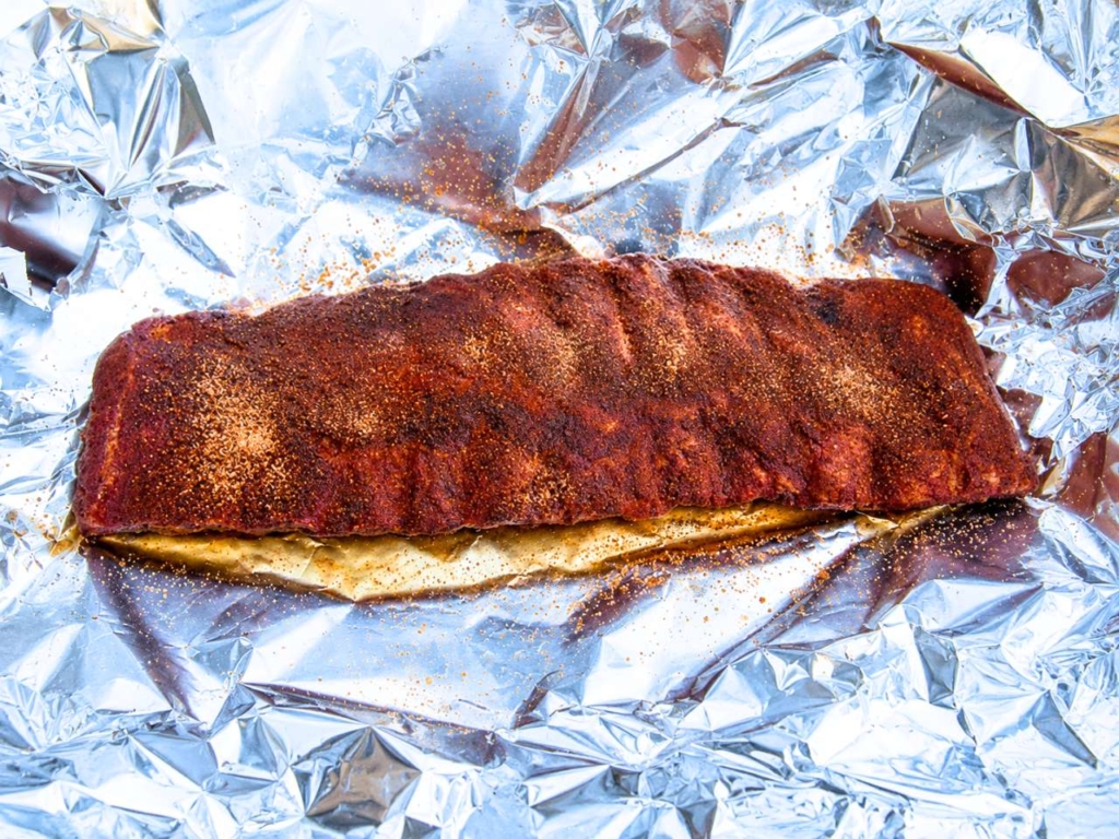 Rack of pork ribs on a sheet of aluminum foil