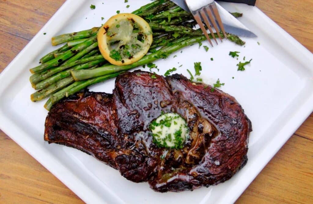 sous vide and seared ribeye stead on a plate with asparagus