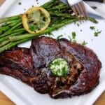 sous vide and seared ribeye stead on a plate with asparagus