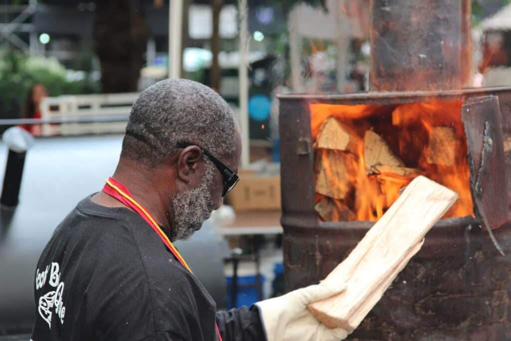 man burning wood in a burn barrel