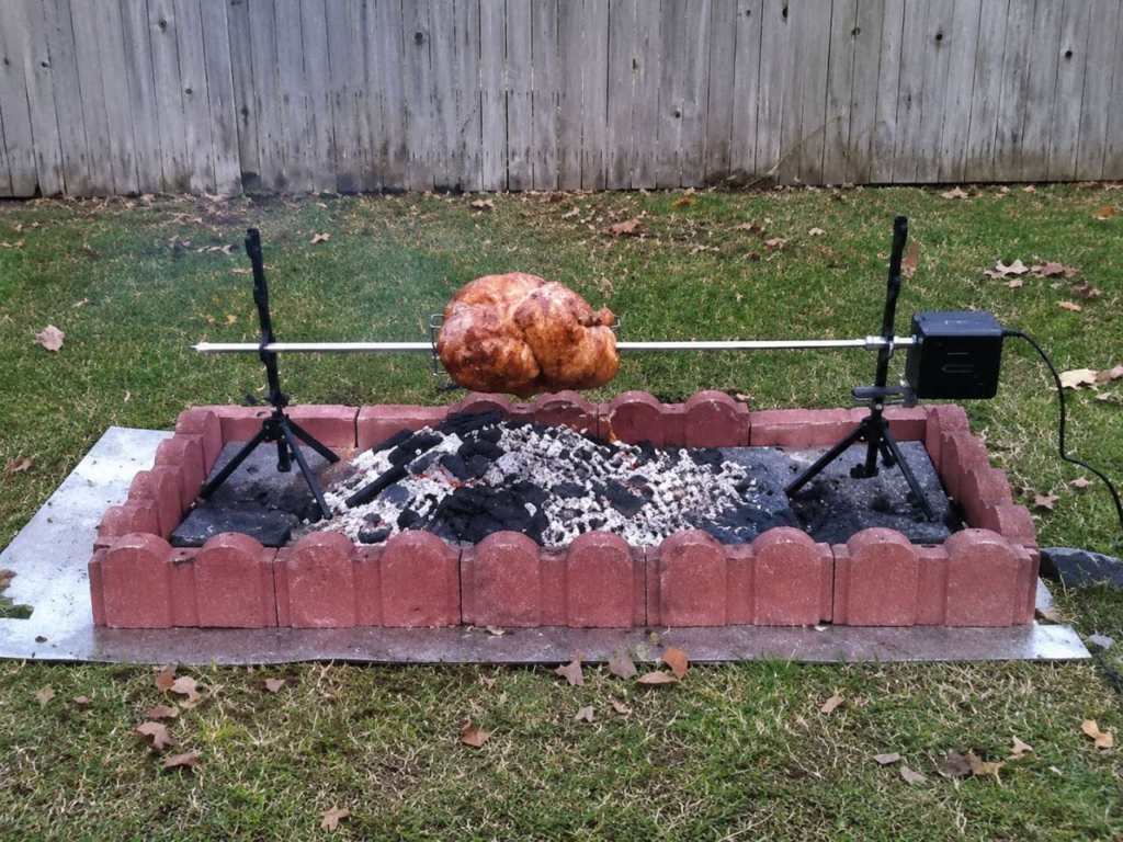 Spitjack rotisserie with a whole chicken above a bed of hot coals.