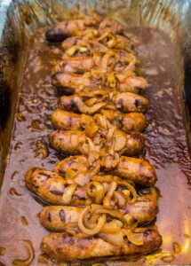 Bratwurst in liquid with onions
