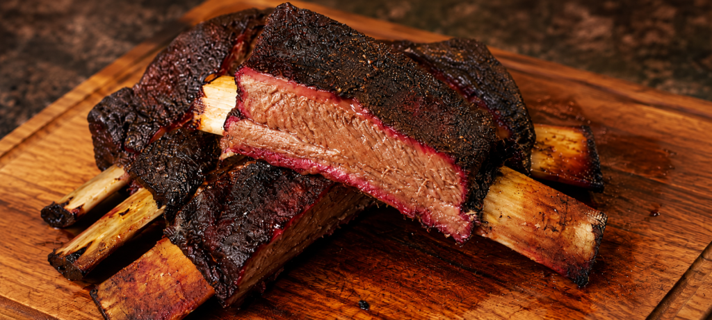Smoked beef ribs on a wooden cutting board
