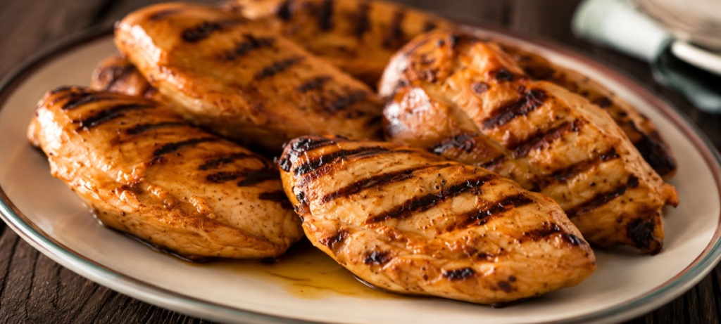 Grilled boneless chicken breasts on a platter.