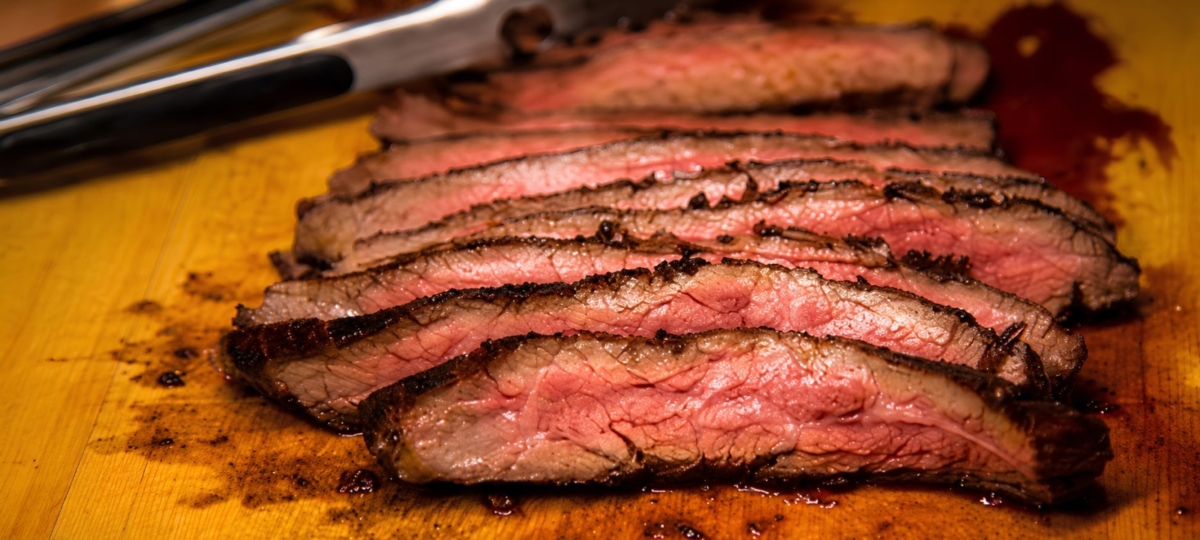 Sliced flank steak topped with chimichurri sauce