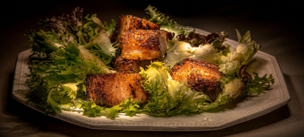 Pork belly croutons on a plated salad.