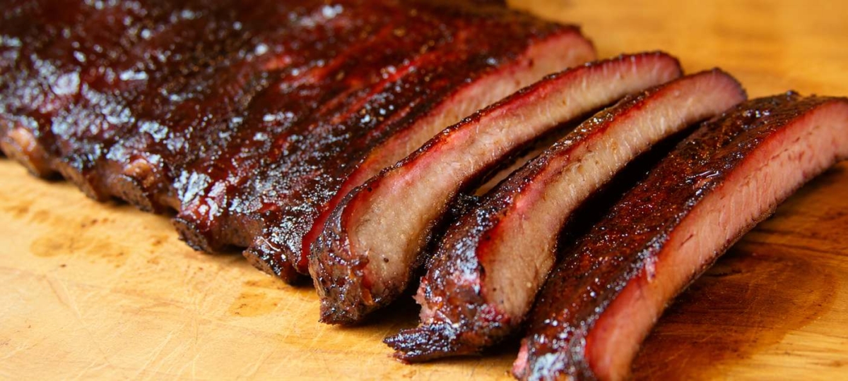 Sliced smoked pork ribs on a wood cutting board
