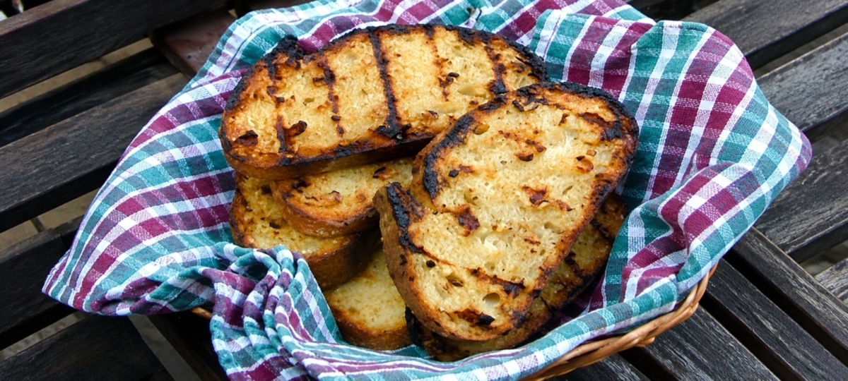 Garlic bread in a basket with a colorful napkin