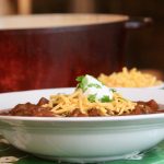 Chili con carne in a bowl with cheese and sour cream