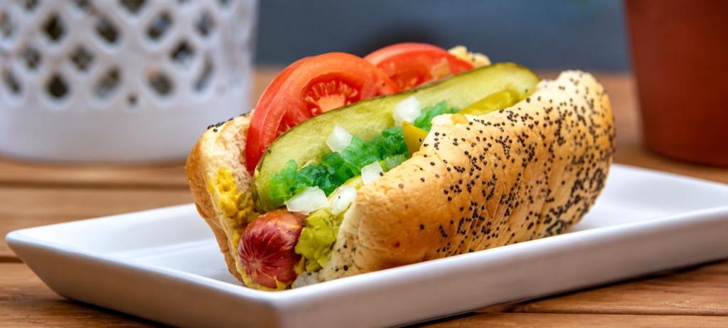 Classic Chicago hot dog on white plate.
