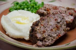 meatloaf on plate with potatoes.