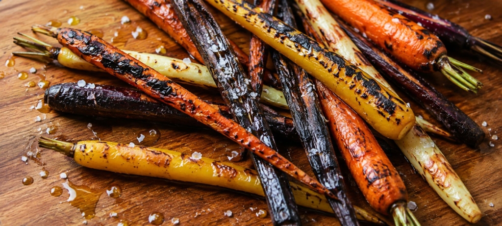 Charred carrots on a cutting board.