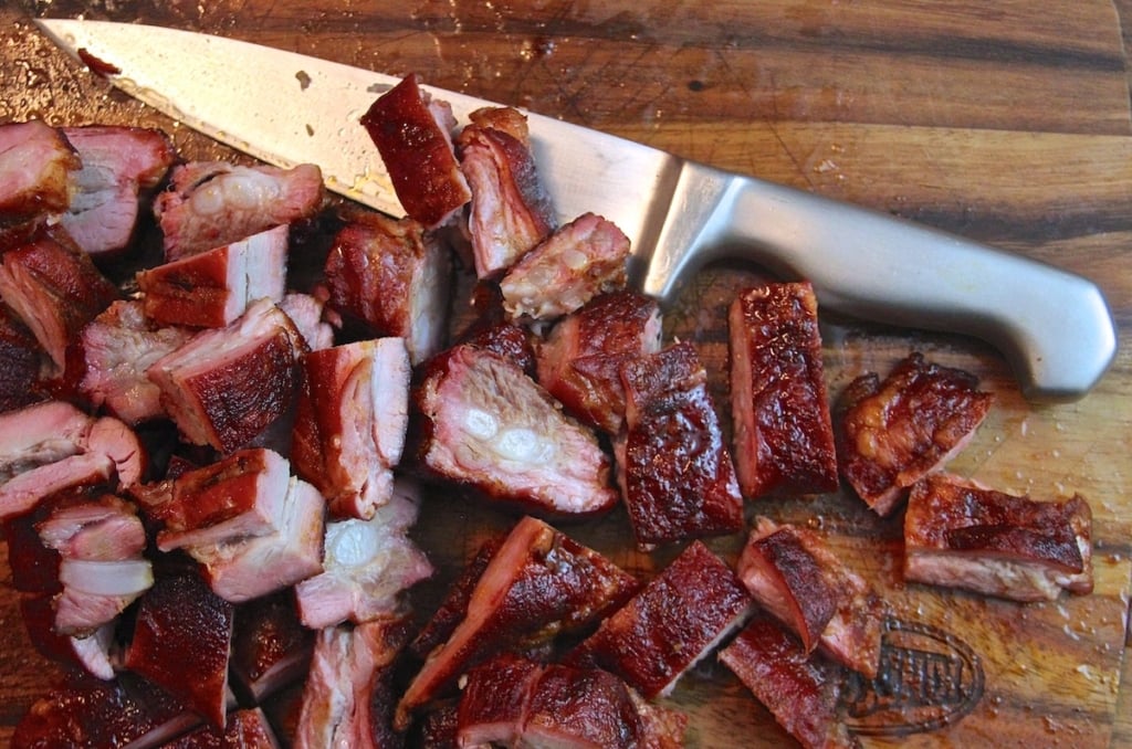 chopped smoked pork tips and a knife on a cutting board