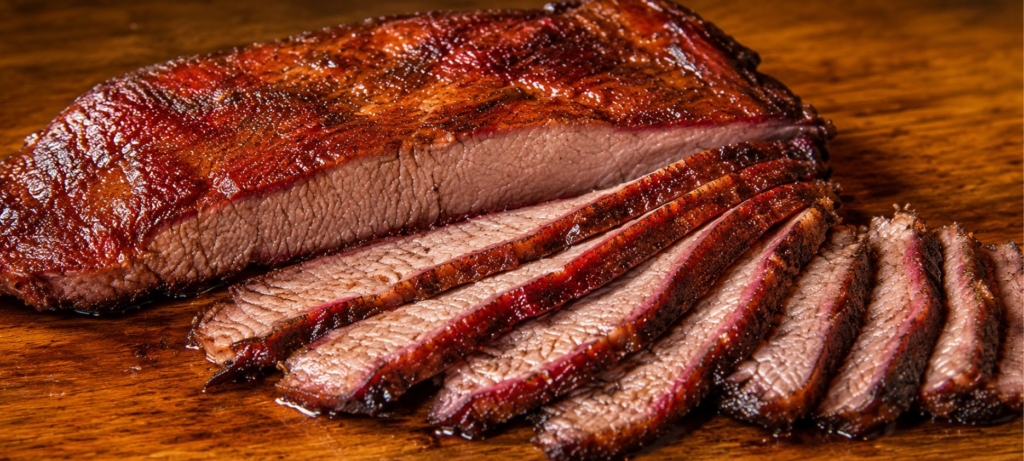 Sliced chuck roast and slicing knife on a wooden cutting board