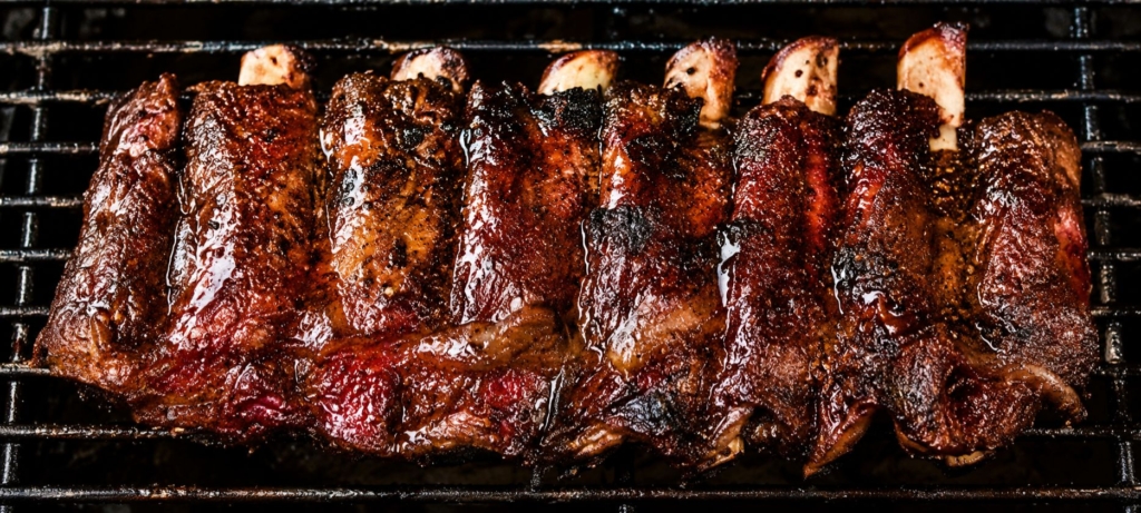 Rack of smoked beef back ribs on a grill grate.