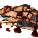Smoked venison ribs sliced and drizzled with sauce