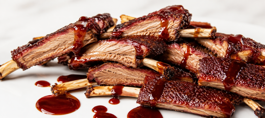 Smoked venison ribs sliced and drizzled with sauce.