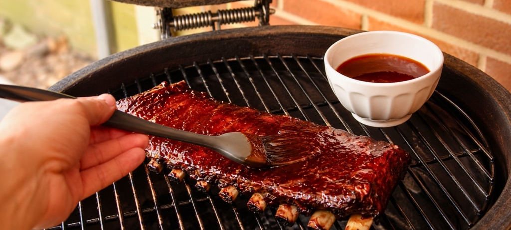 Saucing ribs with soy-ginger glaze from a bowl