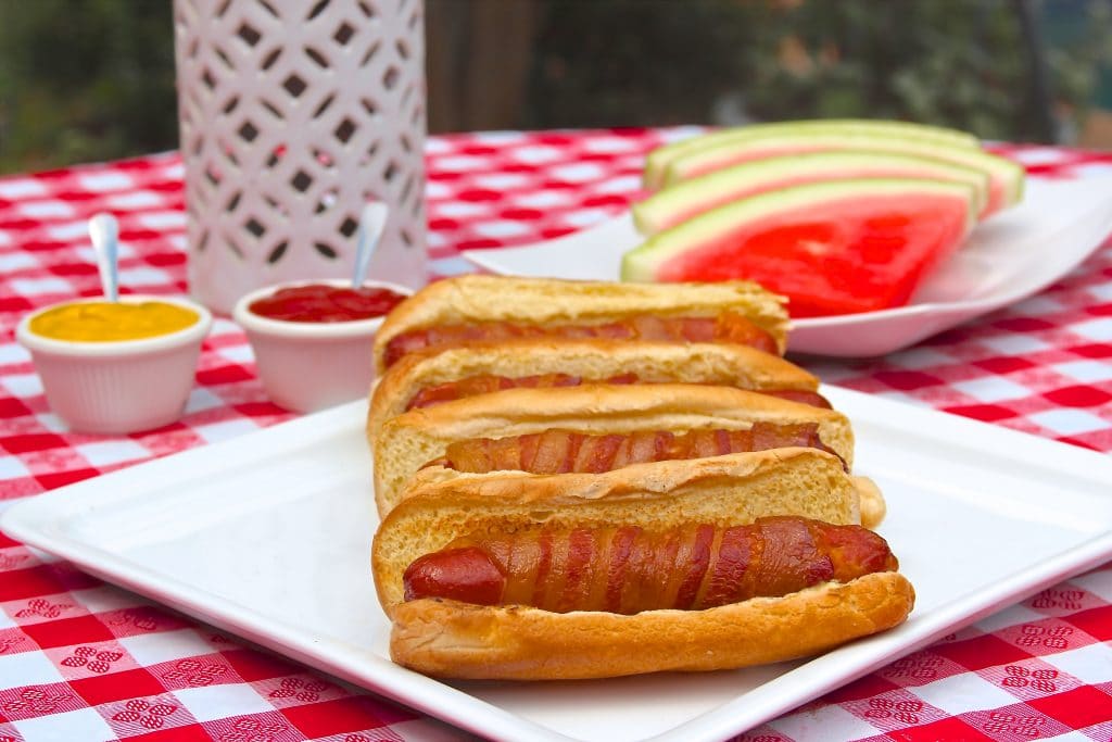 Bacon wrapped hot dogs on a platter