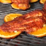 Grilling catfish fillet on orange slices