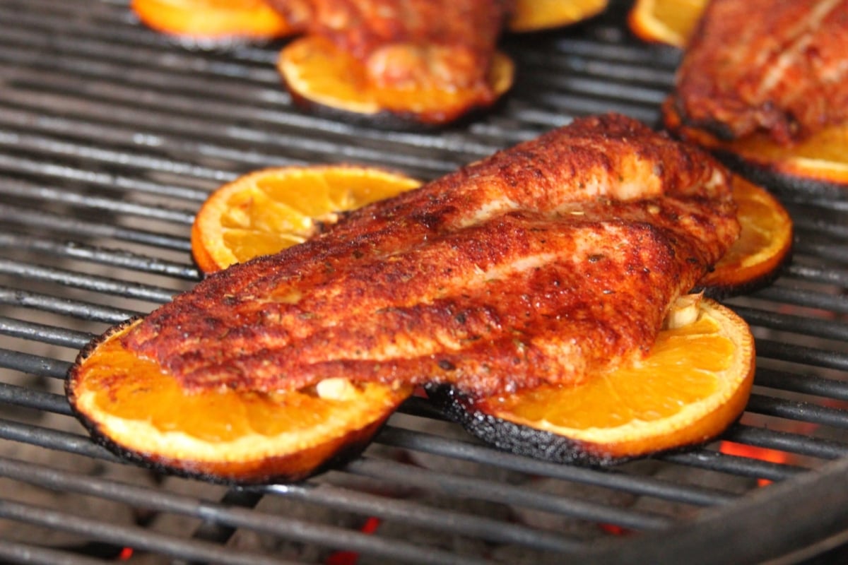 Grilling catfish fillet on orange slices