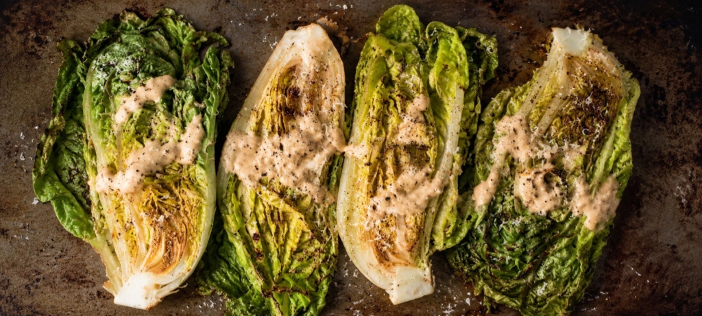 Grilled romain quarters sprinkled with Parmesan cheese.
