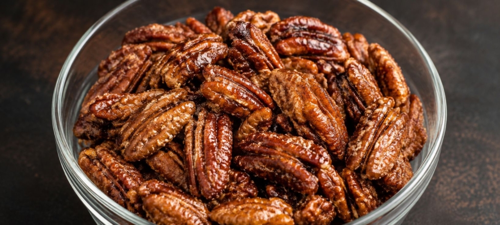 Candied pecans in a glass bowl.