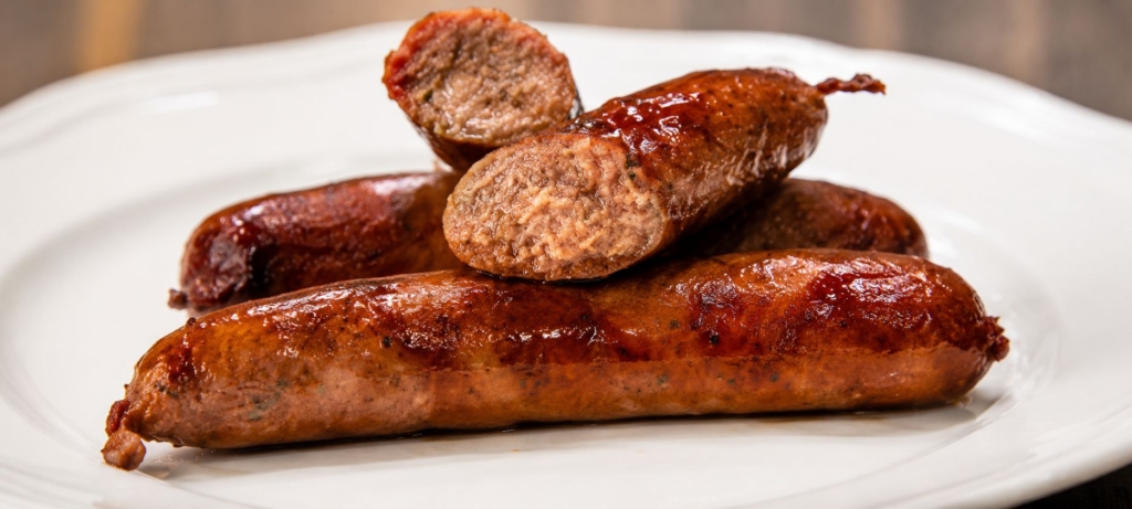 Texas hot guts sausage links on a white plate.