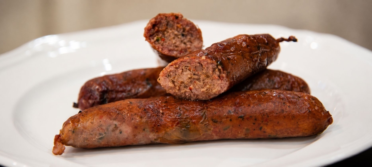 Texas hot guts sausage links on a white plate