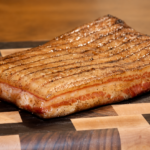 Unsliced maple bacon on a wooden cutting. board