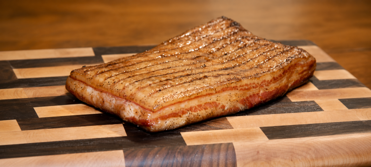 Unsliced maple bacon on a wooden cutting. board