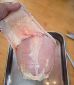 Peeling the skin off of a turkey breast