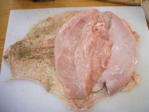 Boneless turkey breast laid on seasoned turkey skin