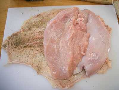 Boneless turkey breast laid on seasoned turkey skin