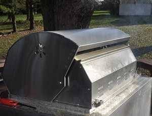 back of a stainless steel gas grill with smoke billowing out