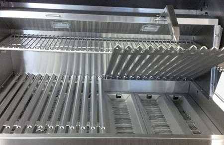heavy stainless steel grates on a gas grill. One grate is lifted up.