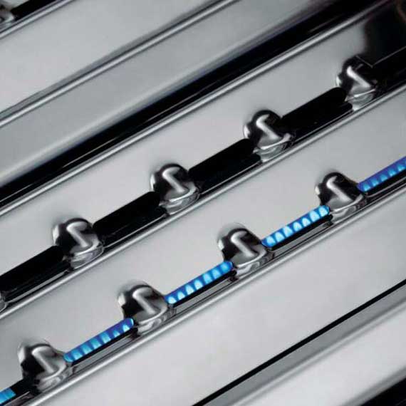 Shiny metal bars with openings in between showing a blue flame underneath.