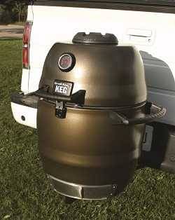 Bronze kamado mounted on the back of a white truck with a trailer hitch.