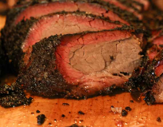 Oval slices of smoked meat showing pink smoke ring.