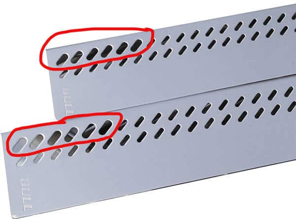 Two shiny metal plates with rows of holes running alond the top. Red pen circles are drawn around the holes on the left side.