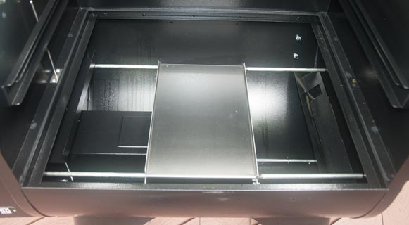 Shiny metal trough with a rectangular metal piece attached to two steel rods.