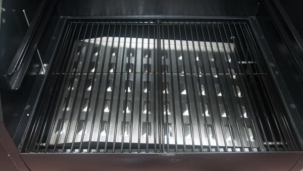Black cooking grates with a shiny metal plate underneath.