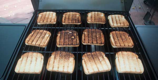 toasted bread spread across a grill grate