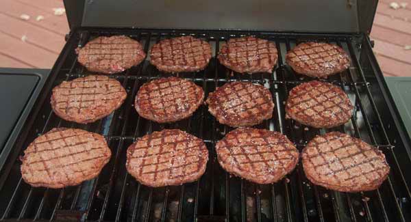 hamburgers cooking on a grill