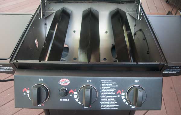 gas grill with lid open showing metal heat diffusers placed of 3 burners