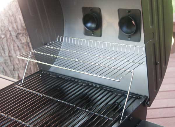 gas grill with lid open showing a warming rack above the main cooking grate